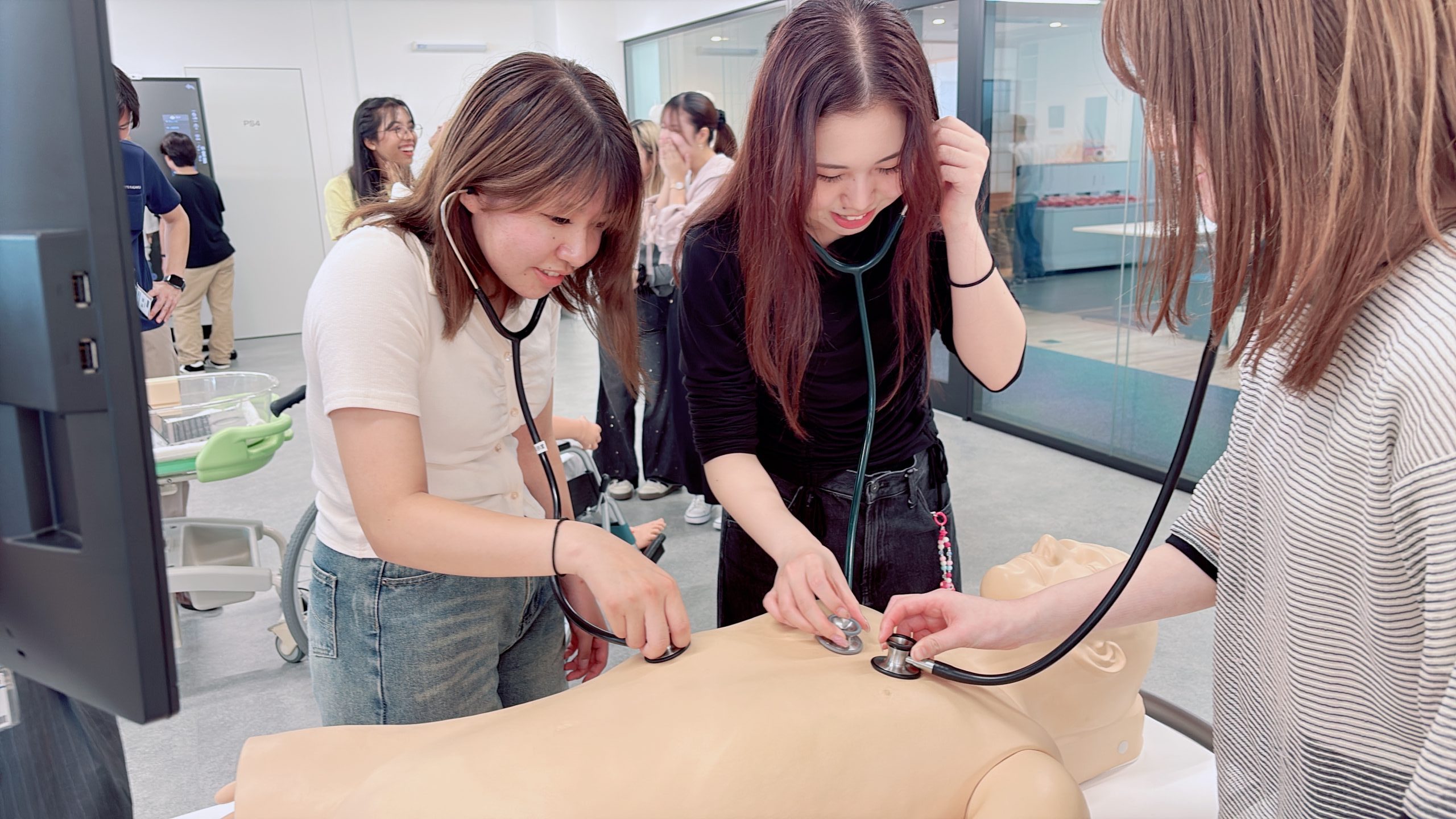 シミュレータに聴診器を当てる学生たち