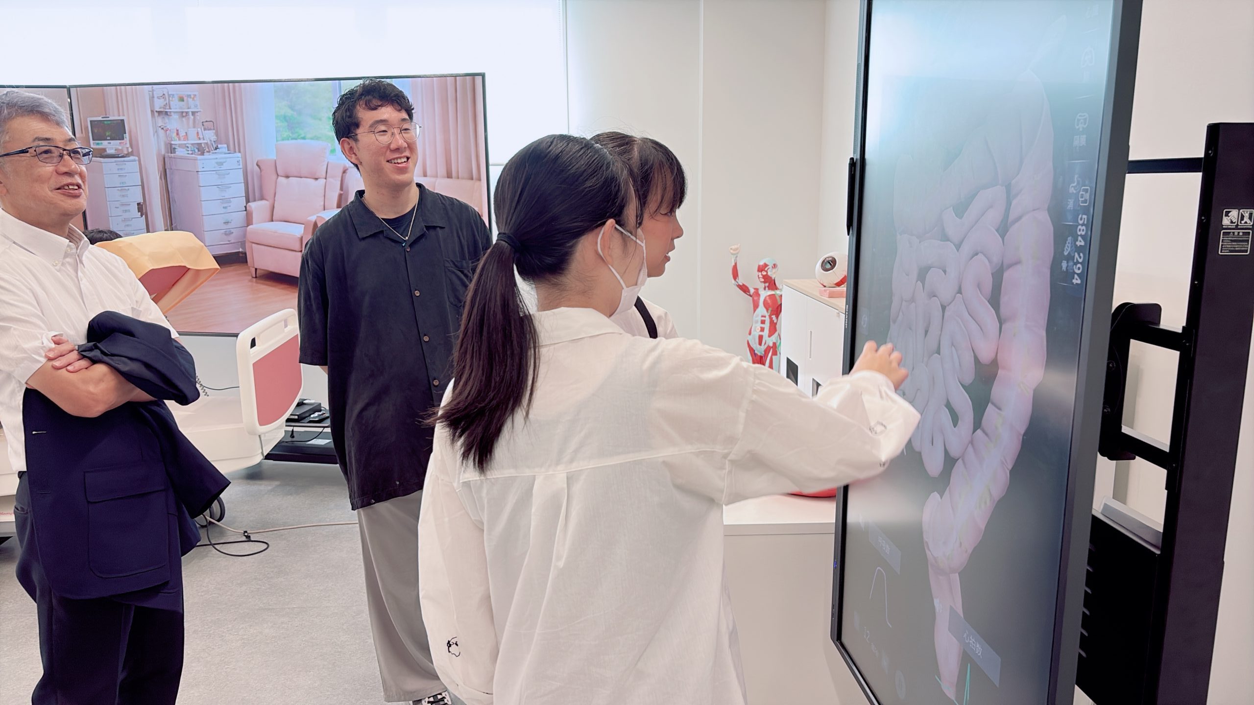 大型画面で人体の構造や筋肉の動きを確認する学生